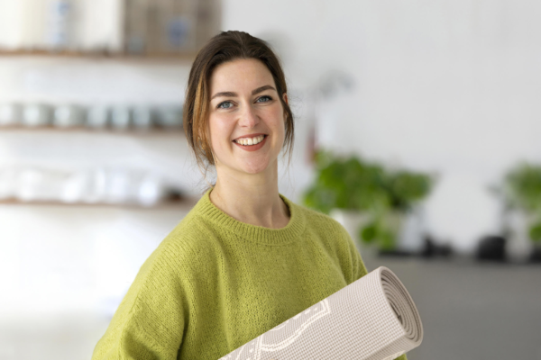Medewerker houdt yogamat vast, want ze heeft haar balansbudget gebruikt voor een yoga-opleiding